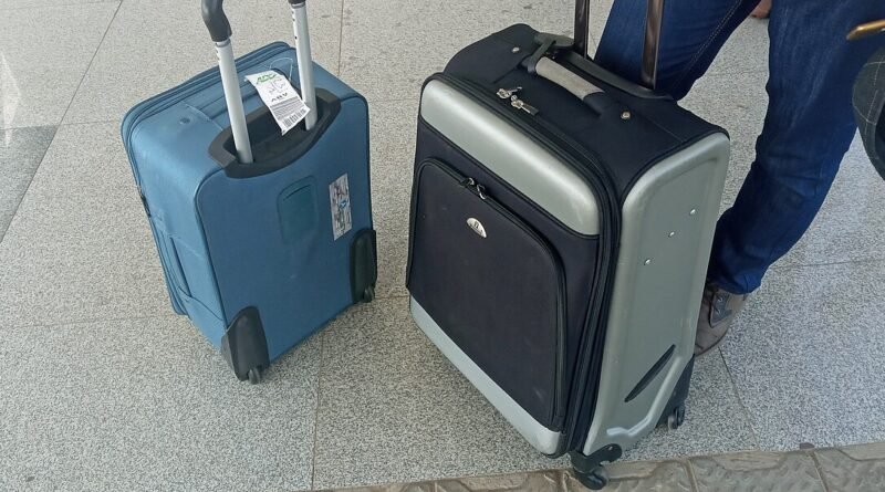 Luggage at an airport for carry-on versus checked bag cost comparison