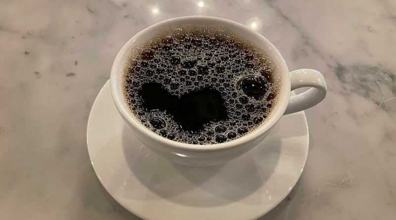 Cup of coffee on a cafe table for a daily coffee cost comparison